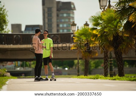 Two handsome male friends arte talking about skateboarding