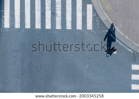 top aerial view of blur men and women people in winter cloth and business dress walk across crosswalk in street. Concept normal life of massive people with transportation and signage on the city road.