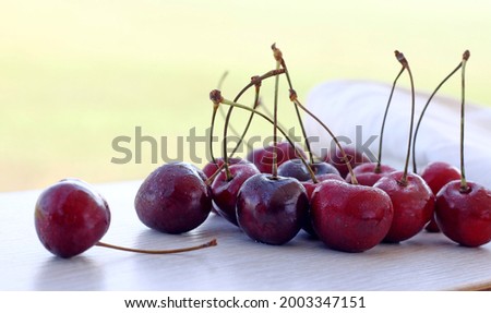 Red cherries with water droplets on the table, one berry separately. on the street
