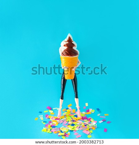 A person holding a big ice cream with confetti on the floor. Celebration, party, summer. Blue background.