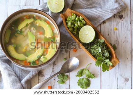 Mexican chicken soup with vegetables. Lime, serran chile and cilantro on the side 