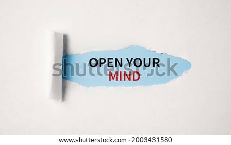Open Your Mind appearing behind torn white paper.Be creative, motivational concept