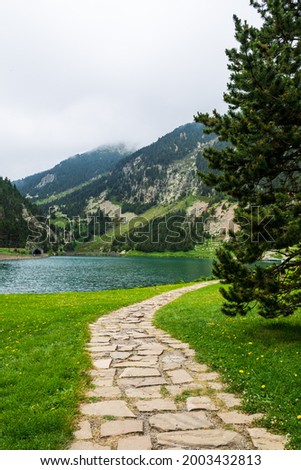 Beautiful stone path leading to the lake in Vall de Nuria valley Sanctuary in the Catalan Pyrenees, Spain,Europe Royalty-Free Stock Photo #2003432813