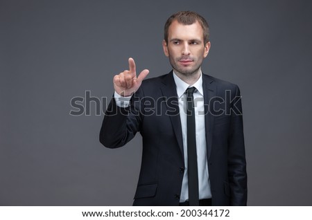 Portrait of manager pointing finger gestures, isolated on grey background. Concept of leadership and success
