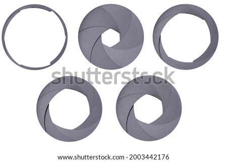 Aperture blades used in a camera lens. Different value of the aperture opening in the optical system. Isolated background.