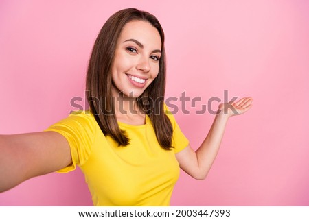 Photo of sweet brunette hair young lady do selfie hold empty space wear yellow t-shirt isolated on pink color background