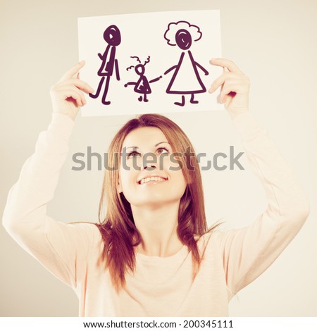 young woman holding picture with happy family. Photo with instagram style filters