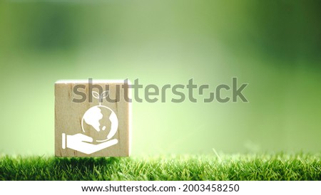 Environment icon on a wood block in green nature background.
save the earth the clean planet, ecology concept with copy space and world environment day concept