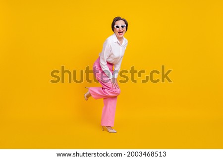 Full length photo of aged excited woman happy positive smile have fun isolated over yellow color background