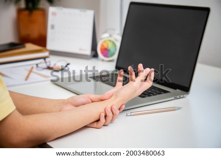 Concept office syndrome hand pain from occupational disease, woman having wrist pain from using computer, wrist pain. Royalty-Free Stock Photo #2003480063