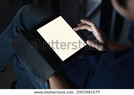 Mockup image of a black tablet with white blank screen on wooden desk