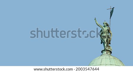 Banner with San Simeone Piccolo Catholic Church, its top dome with statue of Roman man pointing with hand towards sky in Venice, Italy, with copy space blue sky background