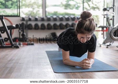 Training gym concept a female teenager doing planking and holding the position for a while as her abdominal and core exercise.