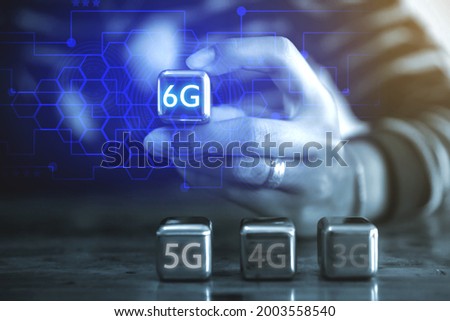 6G Internet and network technology concepts A young businessman using a square steel ball hand and sees the inscription: 6G using a steel ball mobile.