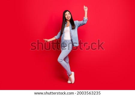 Full length body size view of attractive cheerful carefree girl having fun dancing isolated over bright red color background