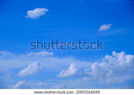 White fluffy clouds in the blue sky in clear weather in summer, winter, spring, nature creates a beautiful background on earth.