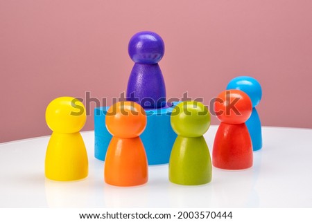 business meeting and social networking concept. Wooden figures of people. the speaker gives explanations to people