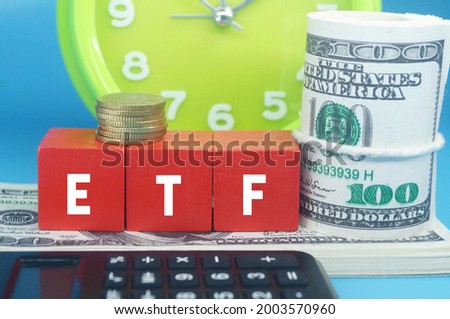 alarm clocks, banknotes, calculators and ETF letters. business concept. Selective focus