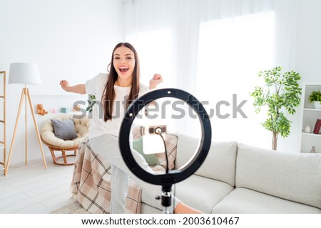 Photo of carefree funny blogger lady dance tripod phone video live broadcast wear white t-shirt pants in room indoors