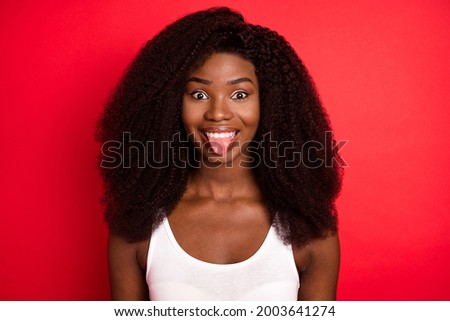 Photo of young african girl happy positive smile fooling grimace tongue-out funny isolated over red color background