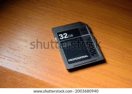 Close up macro shot of 32GB SD memory card on the wooden top surface