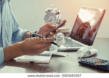 The man holding paper bills using calculator app. Calculation Financial Budget Count Tax Vat Wage Concept Royalty-Free Stock Photo #2003683307