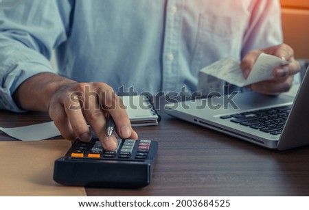 Accountant holding paper bills using calculator . Calculation Financial Budget Count Tax Vat Wage Concept Royalty-Free Stock Photo #2003684525