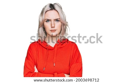 Young blonde girl wearing casual clothes skeptic and nervous, disapproving expression on face with crossed arms. negative person. 