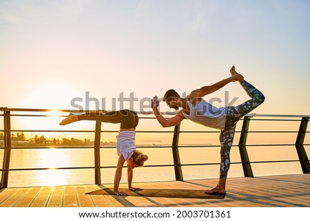 Safety morning exercises in quarantine conditions. Couple doing practicing yoga together on nature outdoors . Morning exercises at the sunrise. 