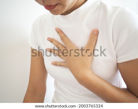 Diaphragmatic hernia. Asian woman have a burning sensation in their breasts. chest pain, shortness of breath. health concept. closeup photo, blurred. Royalty-Free Stock Photo #2003765324