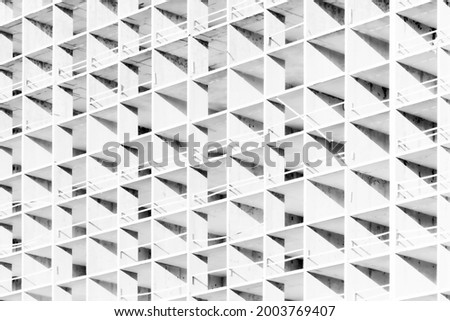 The light or bright black and white background or backdrop of new concrete building construction in the rays of midday sun with many lines, squares, rhombs,triangles and rectangles