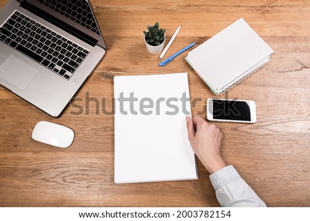 Workspace with laptop, female hands, notebook,eyeglasses, sketchbook,  wooden desk. Flat lay, top view office table desk. Freelancer working place. 