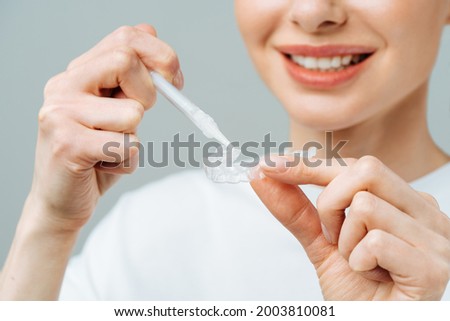 A young woman does a home teeth whitening procedure. Whitening tray with gel Royalty-Free Stock Photo #2003810081