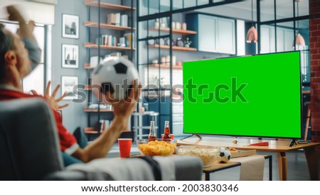 At Home Joyful Soccer Fans Sit on a Couch Watch Green Screen Chroma Key Screen. Friends Cheer for Favourtite Football Sports Team to Win Championship. Over the Shoulder