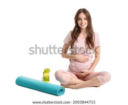 Young pregnant woman with yoga mat on white background