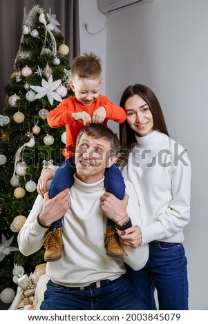Family posing against the background of a christmas tree