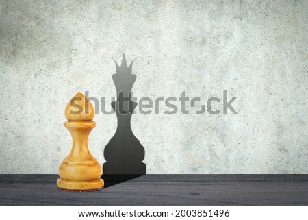 White pawn with the shadow of the queen. Motivation concept. Strength and aspirations. Confidence in your strength. Business. Lifestyle. Abstract background. Background. Royalty-Free Stock Photo #2003851496