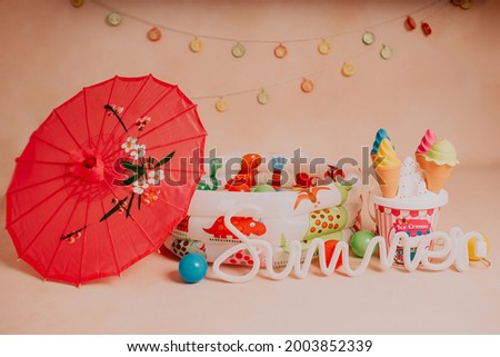 Summer photoshoot in studio for kids with ball swimming pool umbrella and ice cream
