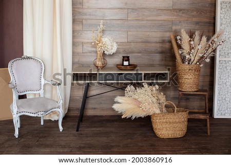 Interior workspace home. Scandinavian style home office interior. Cozy design room home in brown tones: wooden table, armchair, wicker baskets with dried flowers and pampas grass. Work from home