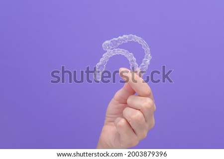 close up of woman's hand holding invisalign braces in studio, dental healthcare and Orthodontic concept.	 Royalty-Free Stock Photo #2003879396