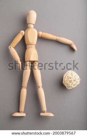 Wooden mannequin playing football on gray pastel background. copy space, isolated, sports concept.