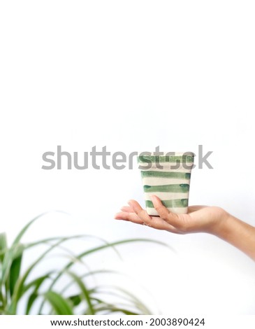 one hand holding a pot with stripes
