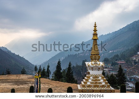Buddhist stupa with himalayan mountain background and dramatic sky at morning from top angle image is taken at dirang monastery arunachal pradesh india.