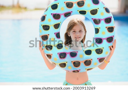 The concept of recreation at sea. The girl holds an inflatable circle for swimming by the pool