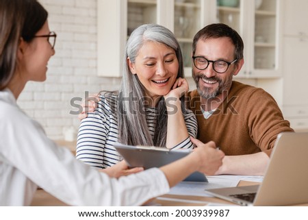 Lawyer financial advisor helping consulting showing contract mortgage loan credit business startup, signing documents by matute middle-aged couple at home Royalty-Free Stock Photo #2003939987