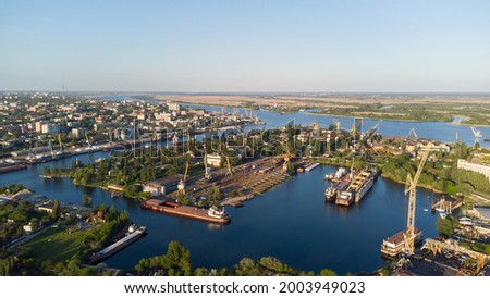 Aerial view of the Kherson city. The Dnieper River of which there are cranes and ships. Residential area with houses and greenery Royalty-Free Stock Photo #2003949023