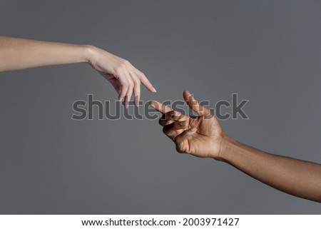 Male and female hands reaching out to each other copying creation of Adam sign. Royalty-Free Stock Photo #2003971427