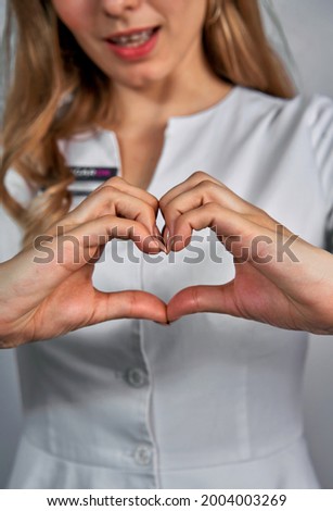 Close up of two female caucasian hands isolated on white background. Young woman forming shape of heart with her fingers. Horizontal color photography. Point of view shot