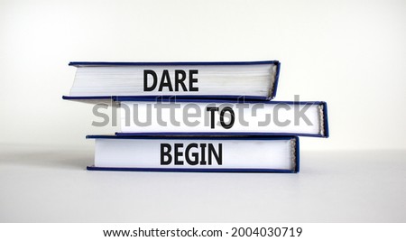 Dare to begin symbol. Books with words 'Dare to begin'. Beautiful white background. Business, dare to begin concept, copy space.