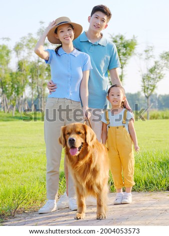 Happy family of three and pet dog in the park high quality photo